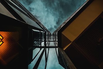 low angle photography of high-rise building under blue clouds