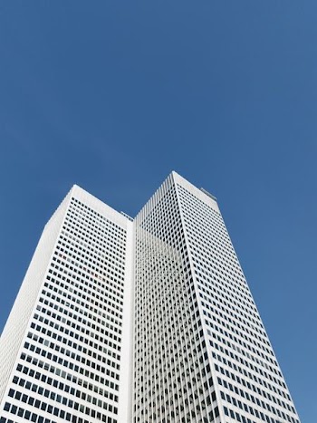 low-angle photography of high-rise building under calm blue sky