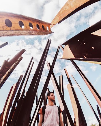 Low Angle Photography of Man Standing Near Steel Posts