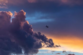 low-angle photography of plane near clouds