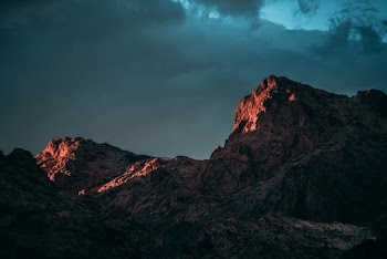 Low-angle Photography of Rock Mountain Under Cloudy Sky