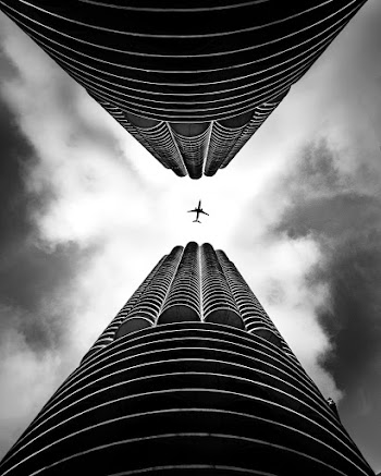 low angle Photography of Two Building With Plane on Middle