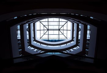 low-angle photography of white building interior with clear glass roof during daytime