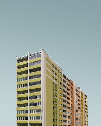 low-angle photography of white, green, pink, and brown concrete buildings