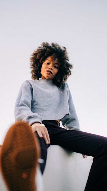 Low-angle Photography of Woman Sitting on a Concrete Wall