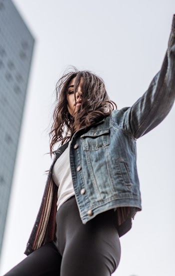 Low Angle Photography of Woman Standing Under Gray Sky