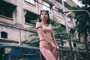 Low Angle Shot A Woman Standing On The Side Of A Street With A Building Across