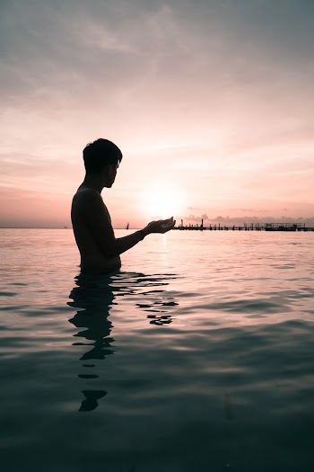 Low Angle Shot Of A Man Standing On Waist Deep Water