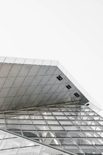 Low Angle Shot Of A Modern Glass Building In Black And White