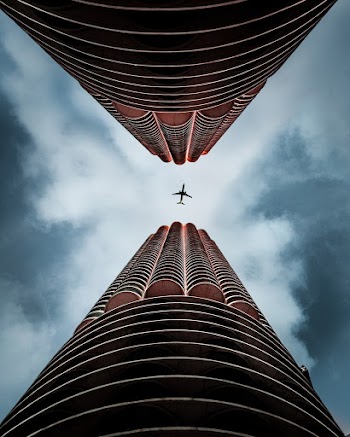 Low Angle Shot of an Airplane Between Two Buildings