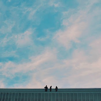 LOw Angle Shot Of Silhouette Of People On Top Of Building