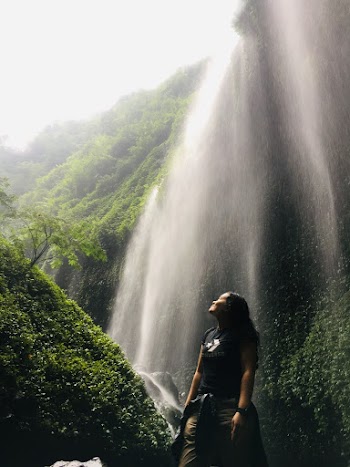 Low Angle Shot Of Woman Standing Under Waterfalls