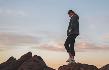Low Angle Side View Photo of Woman Standing on Rock