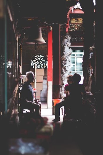 low-light photography of three people sitting on chairs indoors