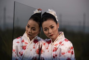 low light photography of woman holding mirror panel