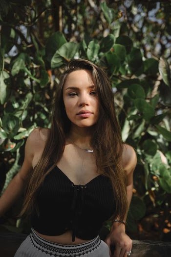 lowlight photography of woman in black crop top near plants