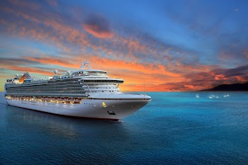 Luxury cruise ship sailing to port on sunrise 