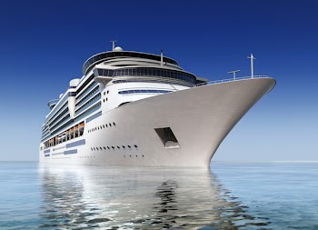 luxury white cruise ship shot at angle at water level on a clear day with calm seas and blue sky