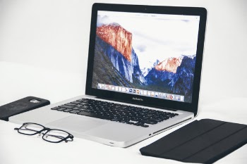 Macbook Air Beside Eyeglasses and Black Smart Case