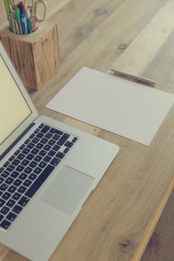Macbook Air Beside White Paper and Click Pen on Top of Table