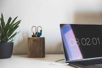 MacBook Air near brown wooden desktop organizer
