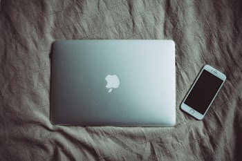 MacBook and iPhone on bed
