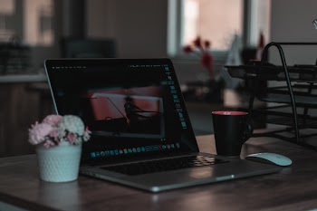 Macbook on Table Beside Mug in Shallow Focus Photography