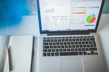 Macbook Pro Beside Notebook With Ballpen