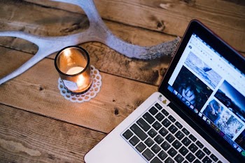 MacBook Pro beside votive candle
