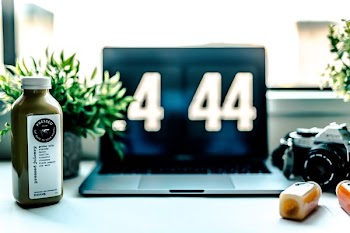 MacBook Pro displaying .4 44 beside camera and bottle
