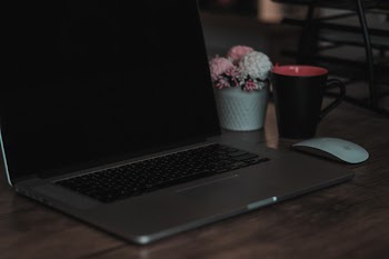 Macbook Pro on Table Near Mug