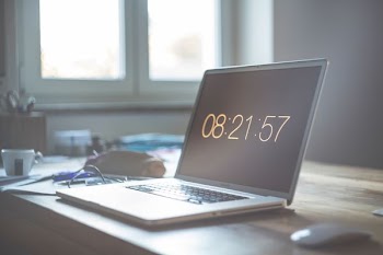 MacBook with Apple Magic Mouse on table near window