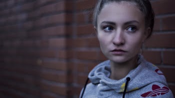 Macro Shot of Woman in Gray Adidas Pull over Hoodie Near Brick Wall