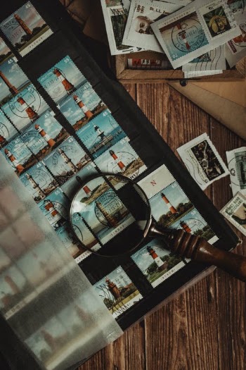Magnifying Glass Lying on Stamp Album  · Free Stock Photo