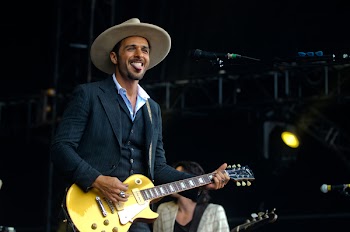 Main in Black Suit Jacket Playing Les Paul Electric Guitar