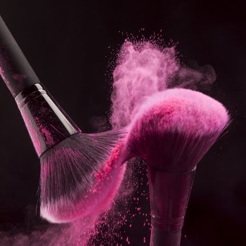 Makeup brushes with pink powder haze Free Photo