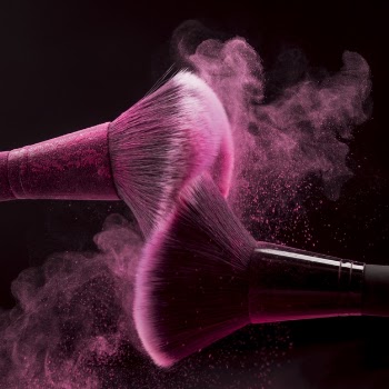 Makeup brushes with pink powder splash Free Photo