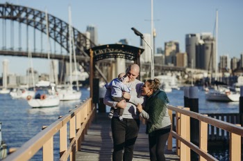 Male and Female With Baby Walking on Wooden Dock