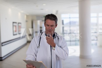 Male doctor dictating notes into tape recorder in hospital