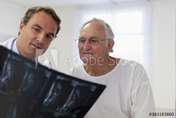 Male doctor showing x-rays to senior patient in hospital