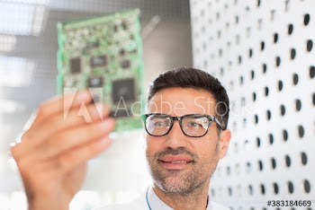 Male engineer examining circuitboard