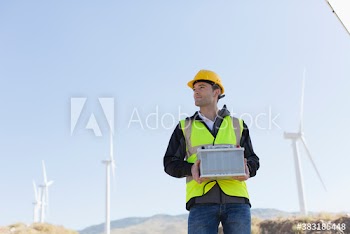 Male engineer with equipment working on wind farm