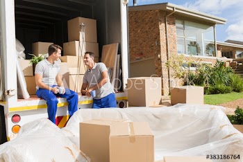 Male movers enjoying coffee break at back of moving van