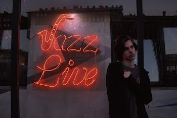 Male Person Standing next to neon sign