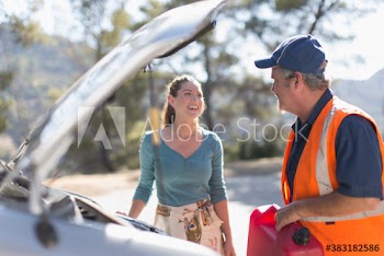 Male roadside assistance worker helping woman with vehicle breakdown