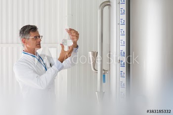 Male scientist examining liquid in beaker
