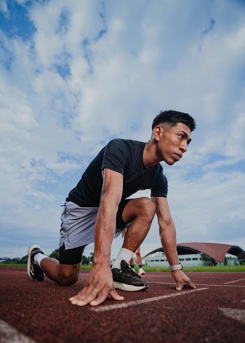 Male Sprinter Preparing for Start on Track