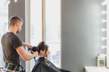 Male Stylist Cutting Hair At Salon