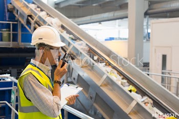 Male supervisor with walkie talkie in recycling plant