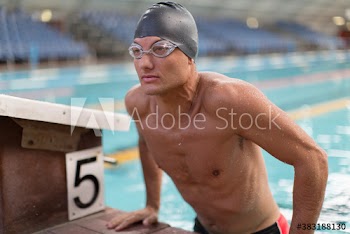 Male swimmer at edge of swimming pool